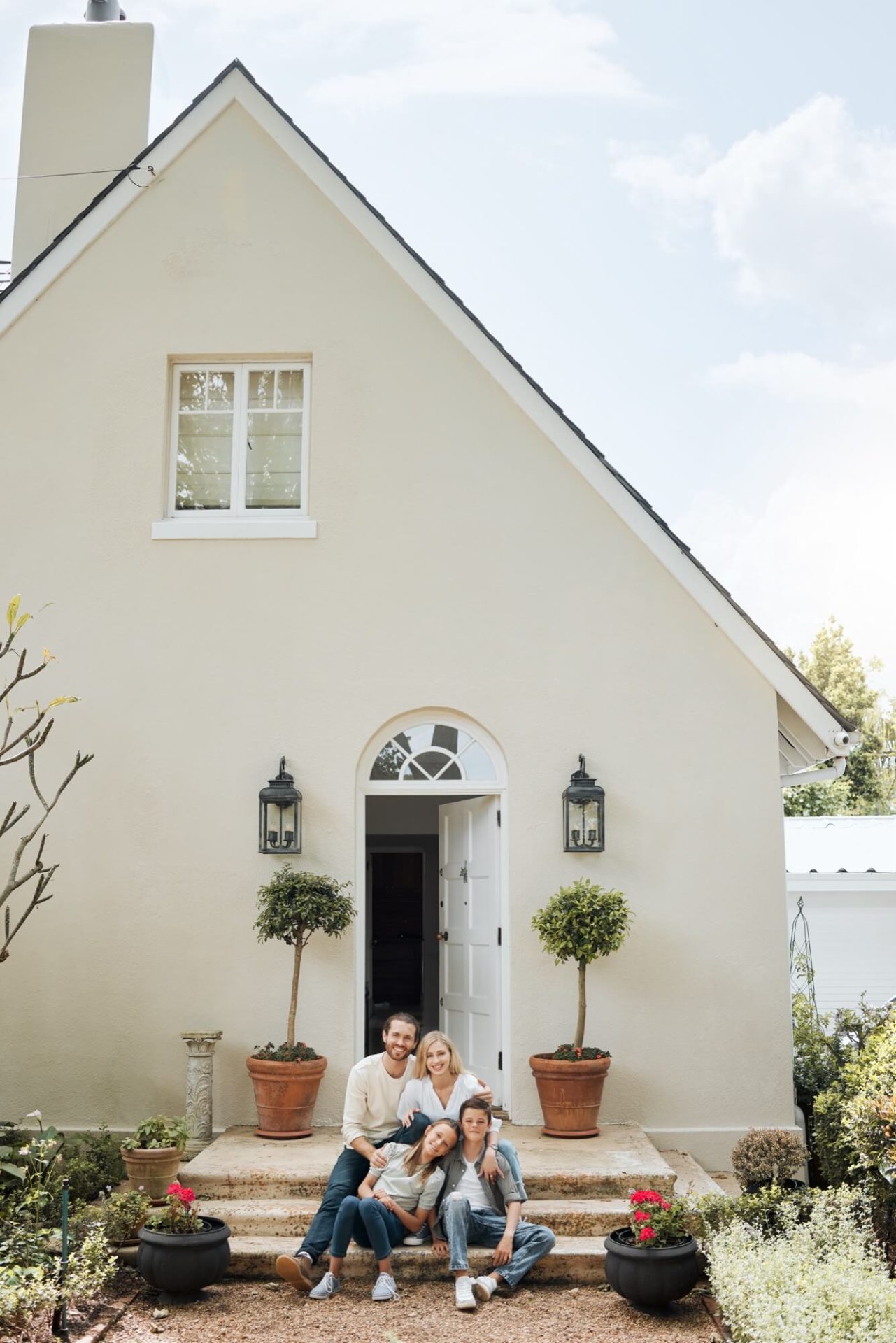 På sin husets trappa, omgivna av en nyligen ljusgjord fasad och entréns grönska, finner vi familjen